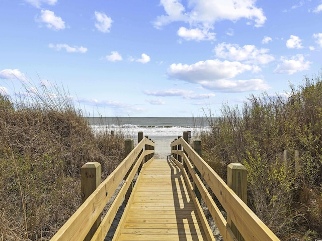 view of home's community with a beach view and a water view