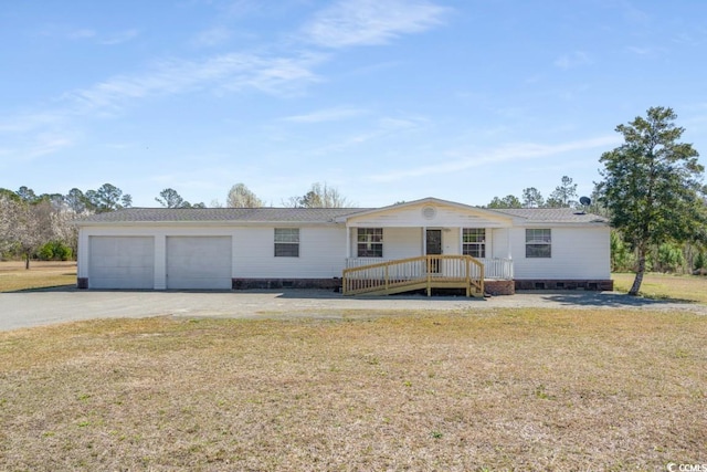 view of front of home featuring a garage, covered porch, and a front lawn