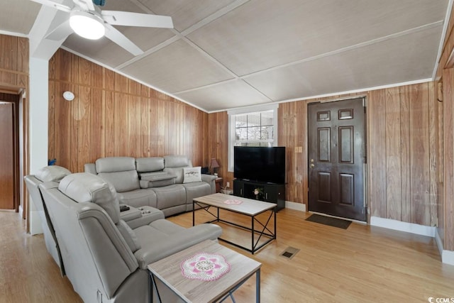 living area featuring visible vents, wood walls, and light wood-type flooring