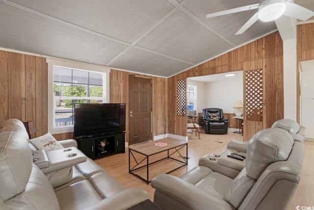 living area with light wood-type flooring, lofted ceiling, wooden walls, and a ceiling fan