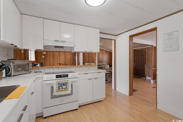 kitchen featuring crown molding, white range with electric cooktop, under cabinet range hood, light wood-style floors, and white cabinets