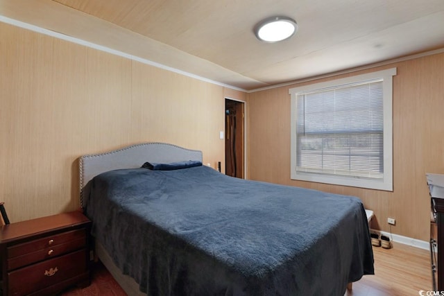 bedroom with baseboards and wood finished floors