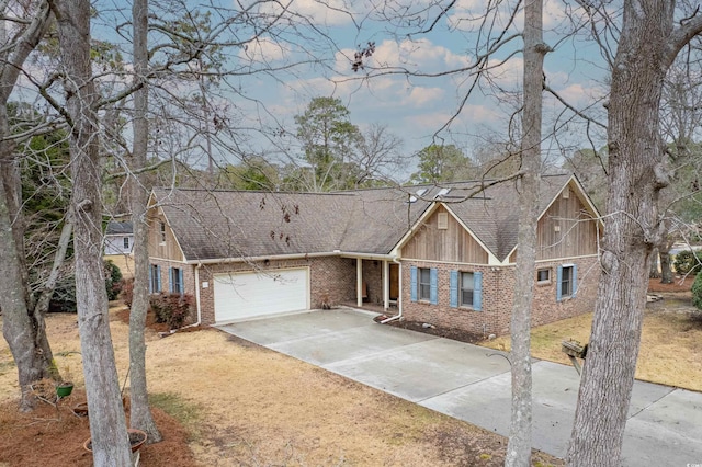 tudor house featuring brick siding, roof with shingles, concrete driveway, and an attached garage