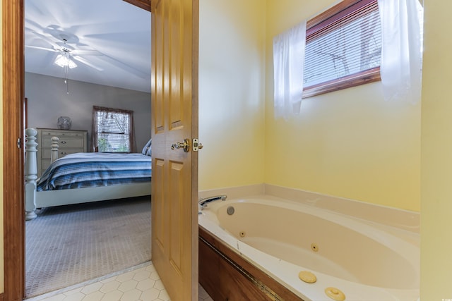 ensuite bathroom featuring connected bathroom, a tub with jets, and ceiling fan