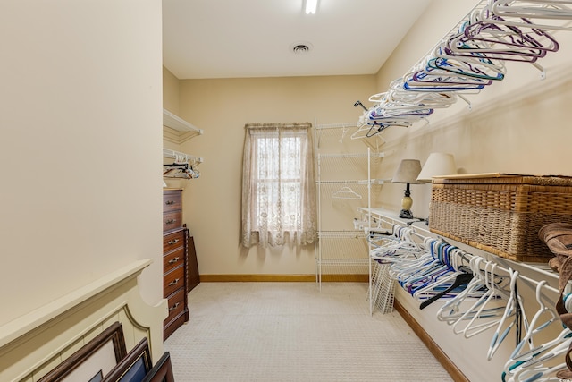 walk in closet with visible vents and light colored carpet