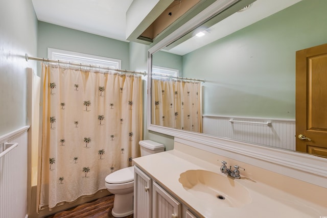 full bath with a wainscoted wall, toilet, vanity, and wood finished floors