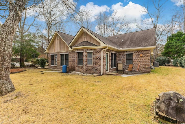 rear view of property with roof with shingles, a yard, central air condition unit, a patio area, and brick siding