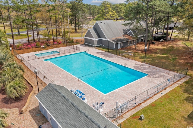 community pool featuring a yard, a patio area, and fence