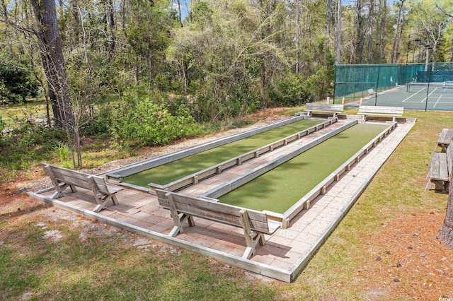 view of property's community with a forest view and fence