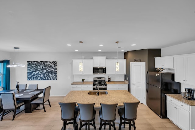 kitchen featuring pendant lighting, a sink, recessed lighting, appliances with stainless steel finishes, and white cabinets