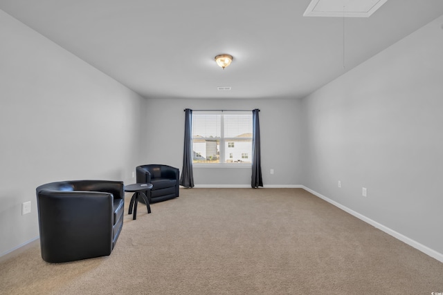 sitting room with baseboards, carpet floors, and attic access