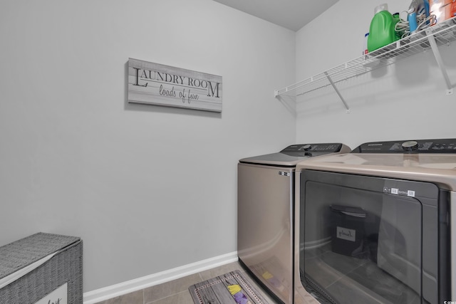 clothes washing area with baseboards, laundry area, and washing machine and clothes dryer