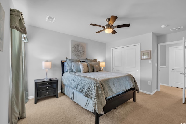 bedroom with visible vents, a closet, and light carpet