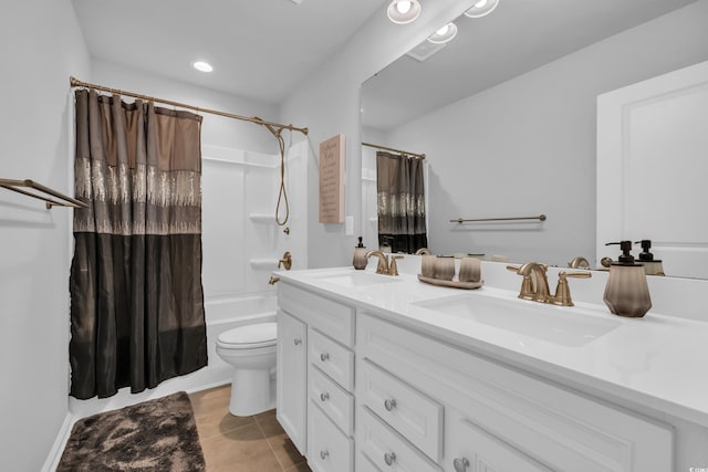 bathroom featuring tile patterned floors, double vanity, toilet, and a sink