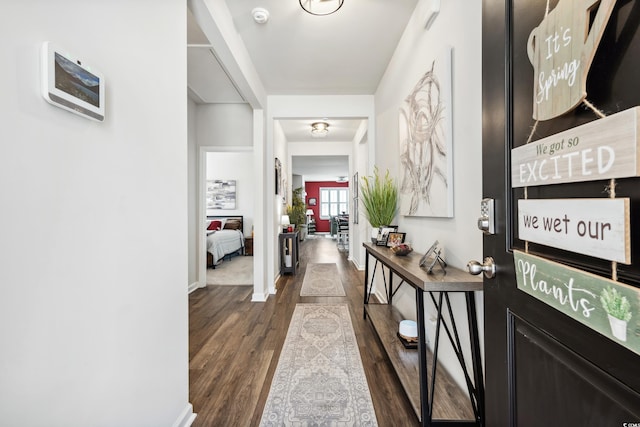 hallway with baseboards and dark wood-type flooring