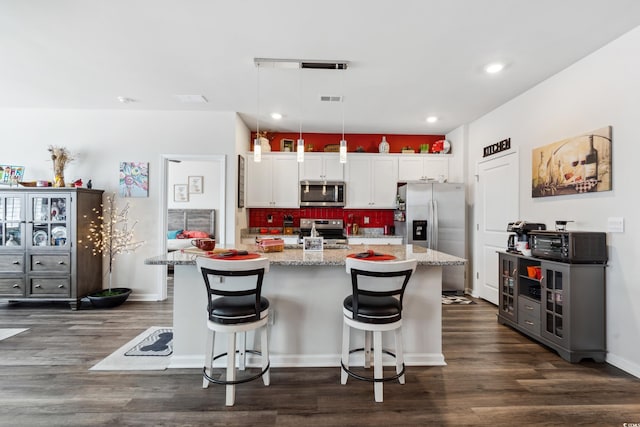 kitchen featuring visible vents, backsplash, stainless steel appliances, white cabinets, and dark wood-style flooring