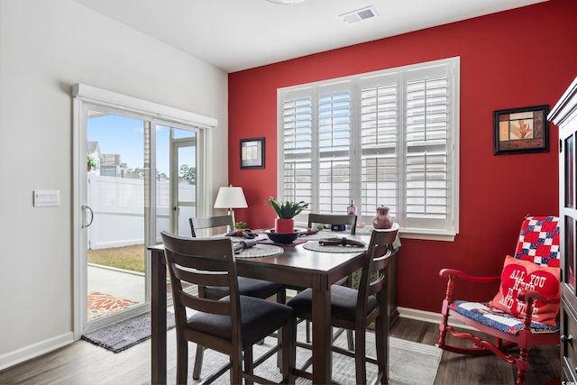 dining area featuring wood finished floors, visible vents, and baseboards