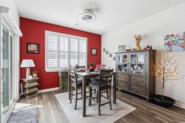 dining room featuring visible vents, wood finished floors, and baseboards