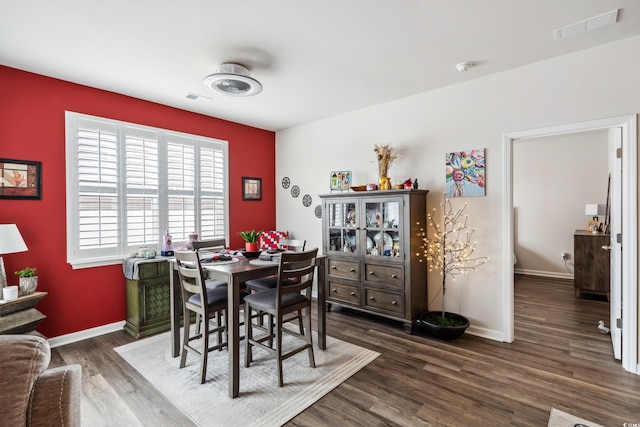 dining area featuring visible vents, baseboards, and dark wood-style flooring