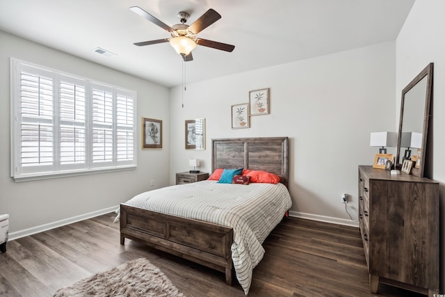 bedroom featuring ceiling fan, visible vents, baseboards, and dark wood finished floors