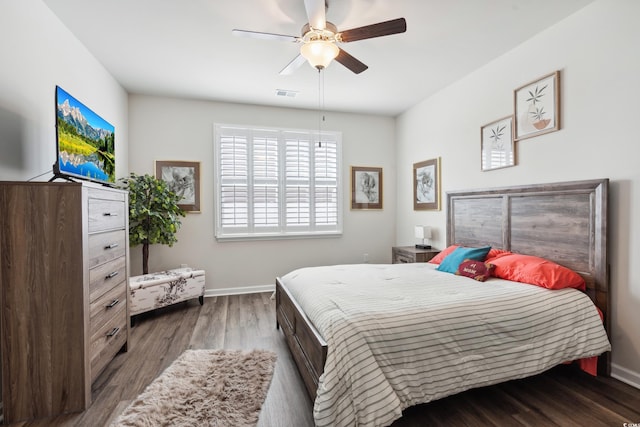 bedroom with visible vents, ceiling fan, baseboards, and wood finished floors