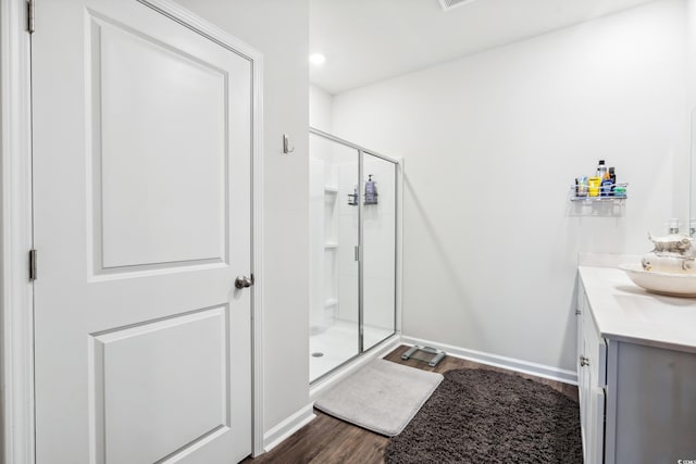 full bath featuring vanity, a shower stall, wood finished floors, and baseboards