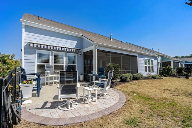 back of property featuring a yard, fence, a patio, and a sunroom