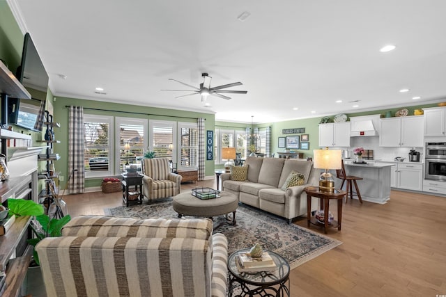 living area with a healthy amount of sunlight, light wood-style flooring, ceiling fan, and ornamental molding