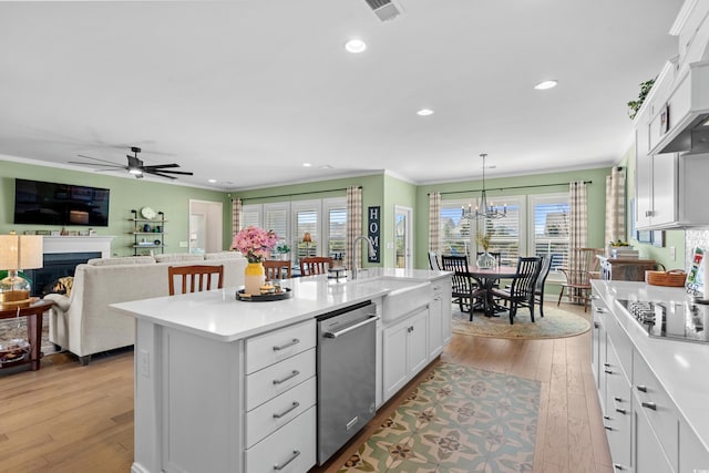 kitchen featuring light wood-style flooring, a lit fireplace, ornamental molding, light countertops, and dishwasher