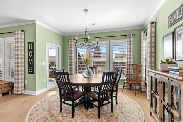 dining area with visible vents, baseboards, ornamental molding, an inviting chandelier, and light wood-style floors