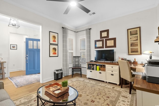 living room featuring visible vents, light wood-style floors, ornamental molding, and ceiling fan with notable chandelier