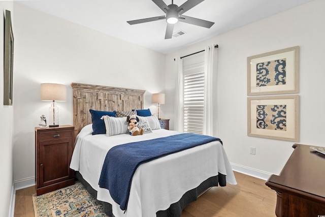 bedroom with visible vents, baseboards, light wood-style floors, and ceiling fan