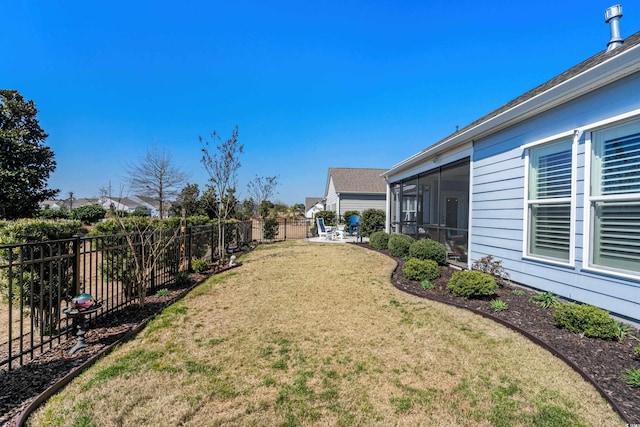 view of yard featuring a fenced backyard and a sunroom