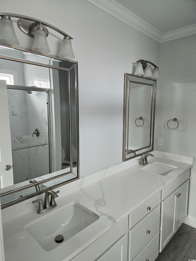 full bathroom featuring a sink, a marble finish shower, ornamental molding, and double vanity