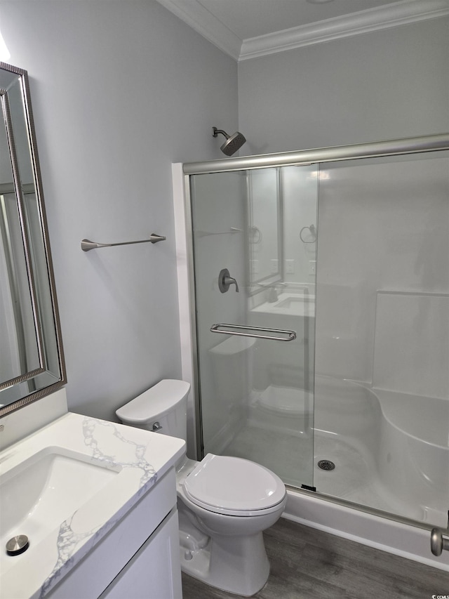 full bathroom featuring toilet, a stall shower, wood finished floors, crown molding, and vanity