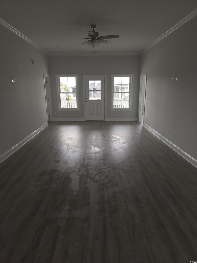 empty room featuring dark wood-style flooring, baseboards, and ornamental molding