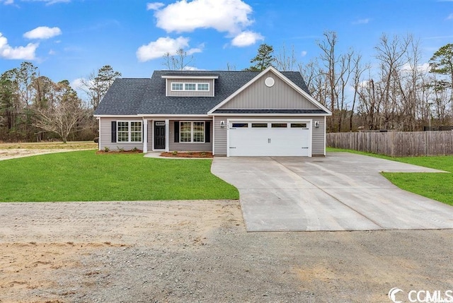 view of front of property with a front yard, fence, driveway, and a shingled roof