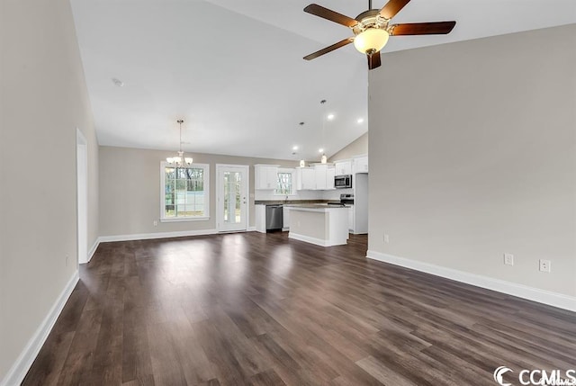 unfurnished living room featuring baseboards, high vaulted ceiling, recessed lighting, dark wood-style flooring, and ceiling fan with notable chandelier