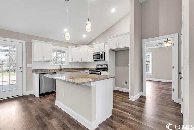 kitchen featuring dark wood-style floors, white cabinetry, stainless steel appliances, and a center island