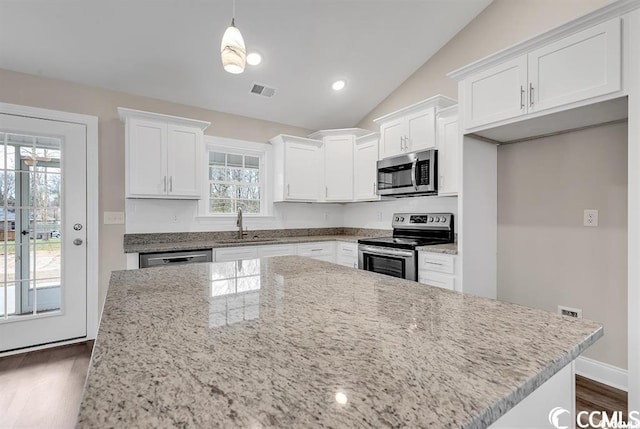 kitchen with visible vents, a sink, stainless steel appliances, white cabinets, and lofted ceiling