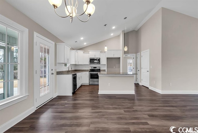 kitchen with dark wood-style flooring, a sink, stainless steel appliances, white cabinets, and a chandelier