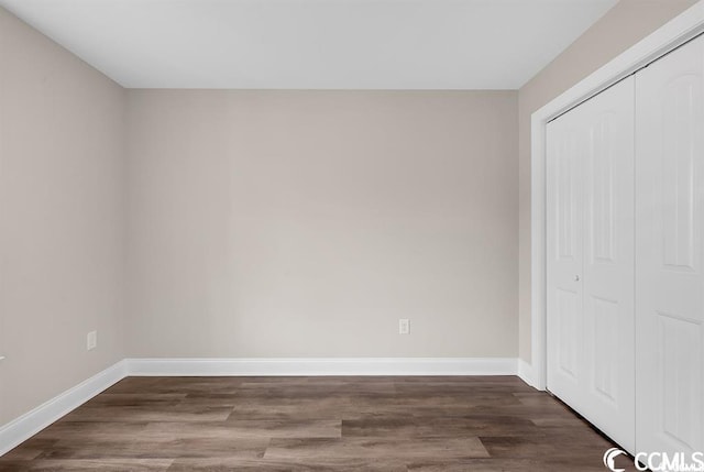 unfurnished bedroom with a closet, baseboards, and wood finished floors