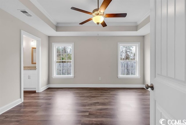 unfurnished bedroom featuring visible vents, multiple windows, and a tray ceiling