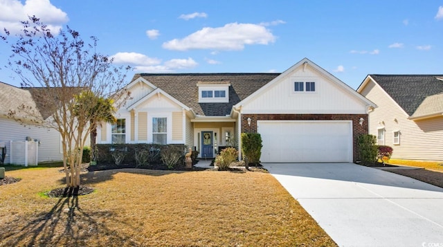 view of front facade with driveway, a shingled roof, a front yard, an attached garage, and brick siding