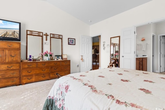 carpeted bedroom with connected bathroom and lofted ceiling