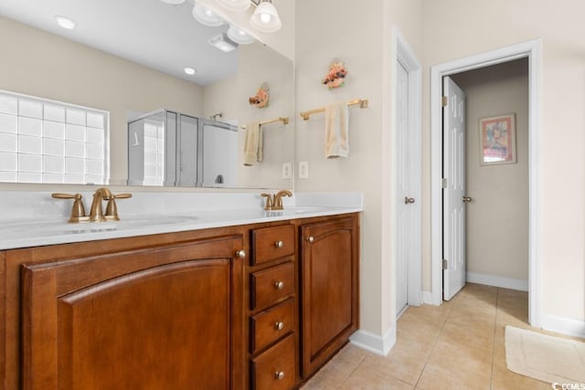 full bath with tile patterned flooring, a shower stall, double vanity, and a sink