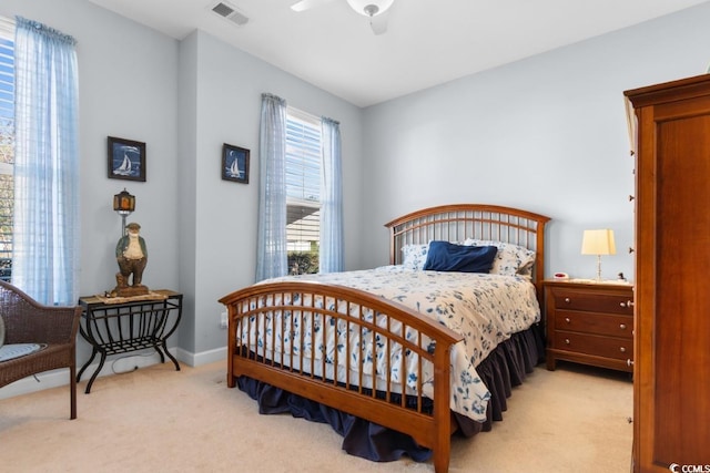 bedroom featuring visible vents, light colored carpet, and baseboards