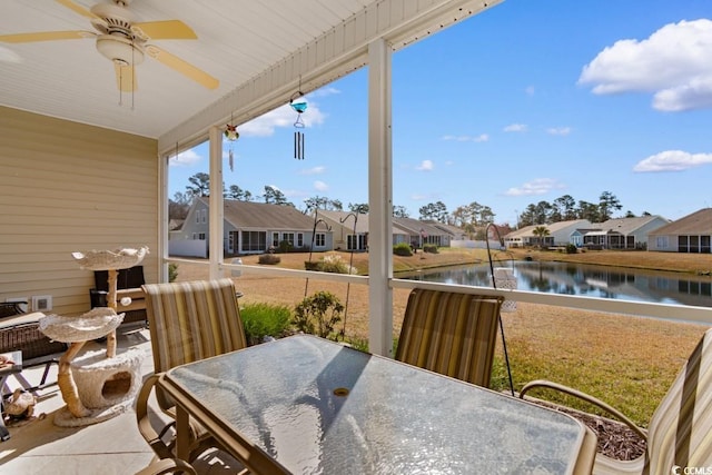 view of patio with a residential view, outdoor dining area, a ceiling fan, and a water view