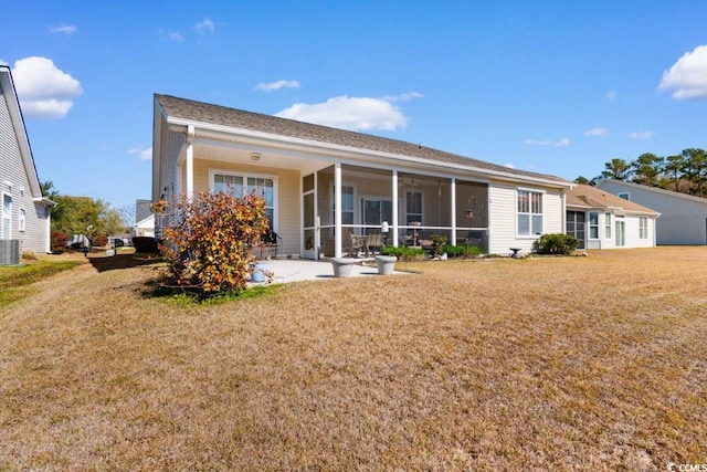 rear view of property with a yard, central AC unit, and a sunroom