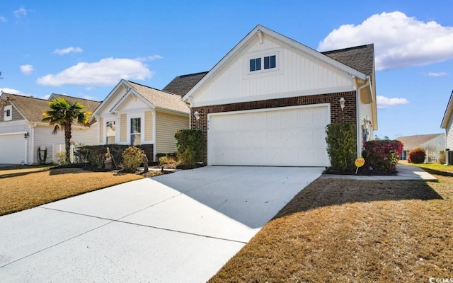 view of front of property featuring brick siding, a front lawn, concrete driveway, and a garage